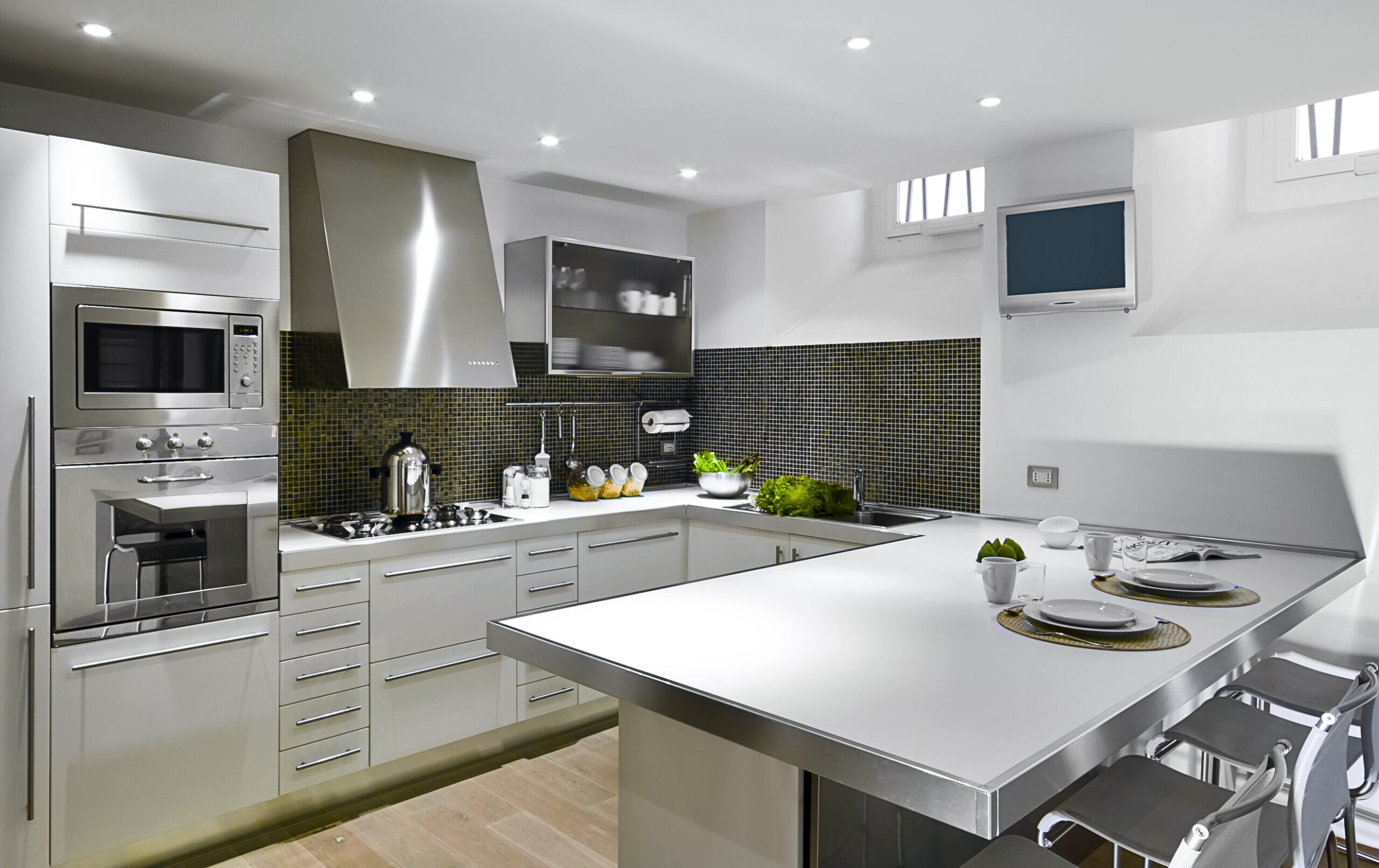 interiors shots of a modern kitchen whose floor is made of hardwood in the foreground the kitchen island in the bottom the kitchen cabinets